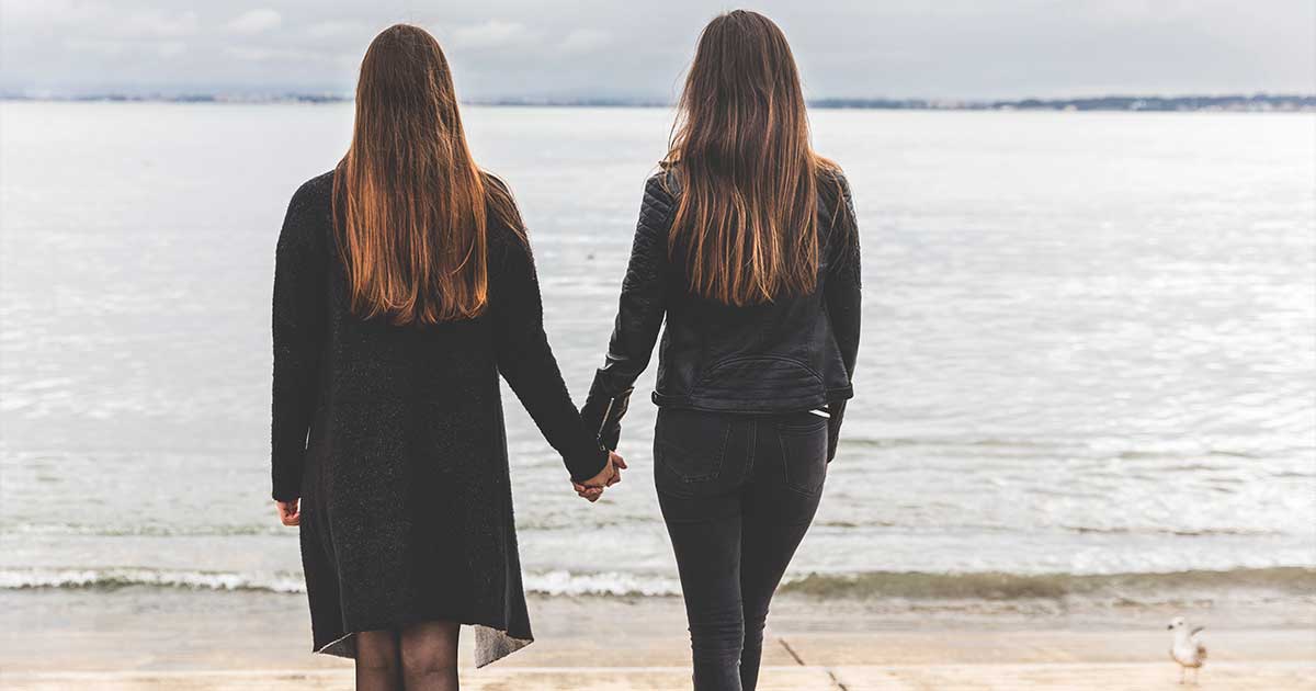 Deux femmes se tenant la main dans la rue, symbole de visibilité lesbienne et d'affirmation publique