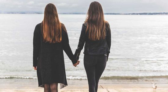 Deux femmes se tenant la main dans la rue, symbole de visibilité lesbienne et d'affirmation publique